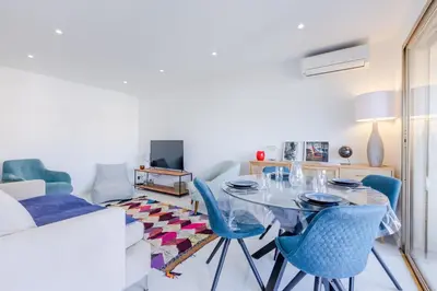 a living room with a glass table and blue chairs at 1-Br Apartment 5 min on foot from the Croisette in Cannes