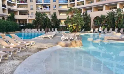 a swimming pool with lounge chairs and a hotel at Joli cozy appartement, aperçu mer, piscine, gardien in Cannes