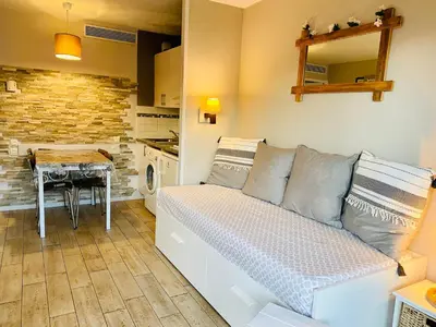 a living room with a couch and a table at Joli cozy appartement, aperçu mer, piscine, gardien in Cannes