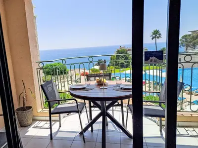 a table on a balcony with a view of the ocean at Apartment Villa Francia-6 by Interhome in Cannes