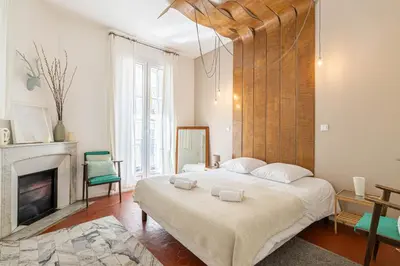 a bedroom with a large bed and a fireplace at Luxurious flat in the heart of Cannes in Cannes
