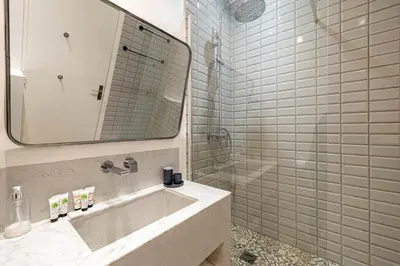 a bathroom with a sink and a shower with a mirror at Luxurious flat in the heart of Cannes in Cannes