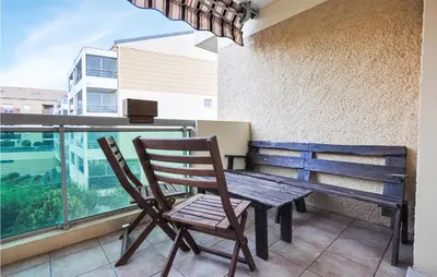 a wooden table and chairs sitting on a balcony at Amazing Apartment In Cannes With Wifi in Cannes