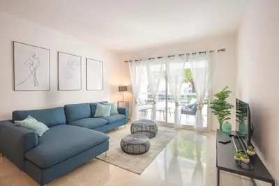 a living room with a blue couch and a tv at Le Dolce Vita by Winsome Destination in Cannes