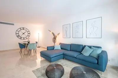 a living room with a blue couch and a table at Le Dolce Vita by Winsome Destination in Cannes