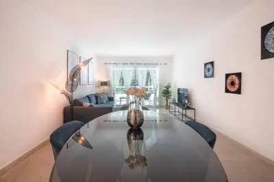 a living room with a table and a couch at Le Dolce Vita by Winsome Destination in Cannes