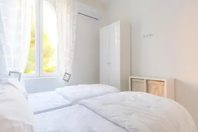 two beds in a white room with a window at CLOSE CROISETTE-MODERN-A/C-CONGRESS-BEACHES in Cannes