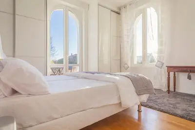 a white bedroom with a large bed with two windows at CLOSE CROISETTE-MODERN-A/C-CONGRESS-BEACHES in Cannes