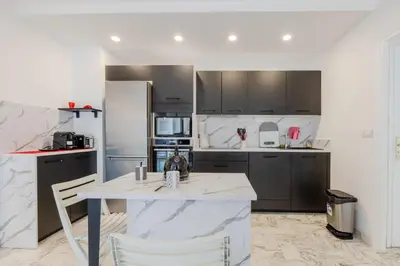 a kitchen with a table and a refrigerator at Renovated 3-Room Apartment in a Leafy Park in Cannes