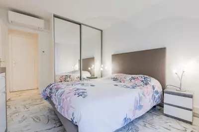 a bedroom with a large bed with a large mirror at Renovated 3-Room Apartment in a Leafy Park in Cannes