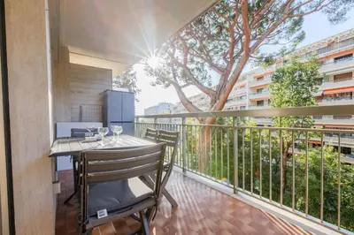 a balcony with a table and chairs and a tree at Renovated 3-Room Apartment in a Leafy Park in Cannes