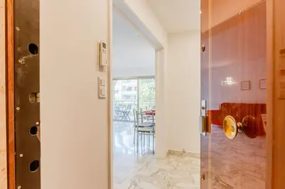 a glass shower door in a room with a table at Renovated 3-Room Apartment in a Leafy Park in Cannes
