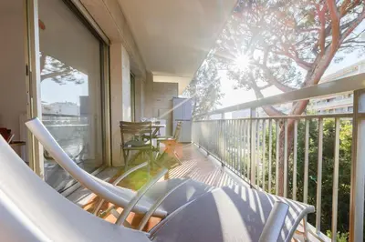 a balcony with a chair and a tree on it at Renovated 3-Room Apartment in a Leafy Park in Cannes