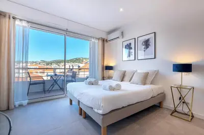 a bedroom with a large bed and a balcony at Agence des Résidences - Appartements privés du 45 CROISETTE - Superieur in Cannes