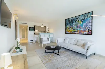 a living room with a white couch and a table at Agence des Résidences - Appartements privés du 45 CROISETTE - Superieur in Cannes