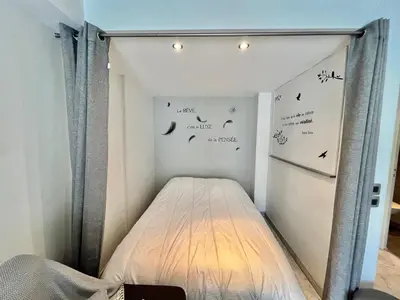 a bed in a room with signs on the wall at Jolies Lavandes, by Welcome to Cannes in Cannes
