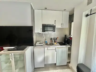 a small kitchen with white cabinets and a sink at Jolies Lavandes, by Welcome to Cannes in Cannes