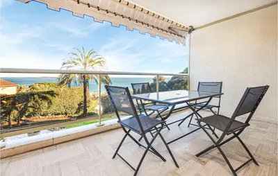 a dining room with a table and chairs and a large window at 1 Bedroom Lovely Apartment In Cannes in Cannes