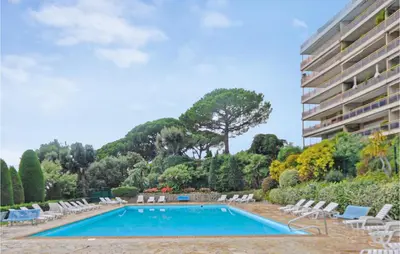 a swimming pool with chairs and a building at 1 Bedroom Lovely Apartment In Cannes in Cannes
