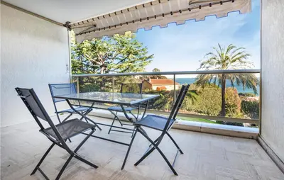 a table and chairs on a balcony with a view of the ocean at 1 Bedroom Lovely Apartment In Cannes in Cannes