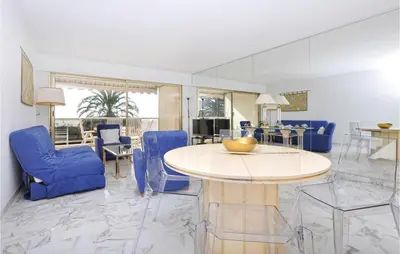 a living room with blue chairs and a table at 1 Bedroom Lovely Apartment In Cannes in Cannes