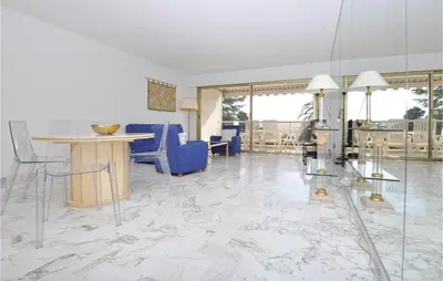 a living room with marble floors and blue chairs at 1 Bedroom Lovely Apartment In Cannes in Cannes
