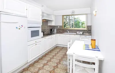 a white kitchen with white appliances and a table at 1 Bedroom Lovely Apartment In Cannes in Cannes