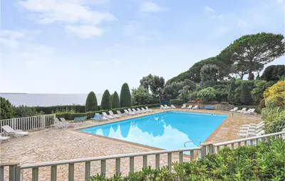 a swimming pool with chairs and a fence at 1 Bedroom Lovely Apartment In Cannes in Cannes