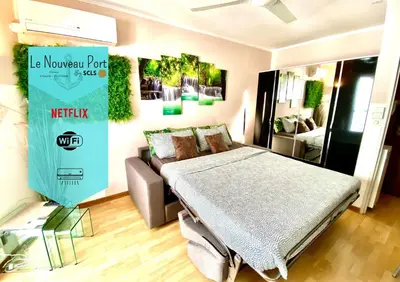 a bedroom with a bed and a couch in it at Le Nouveau Port By SCLS Locations in Cannes