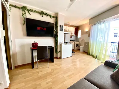 a living room with a table and a tv on the wall at Le Nouveau Port By SCLS Locations in Cannes