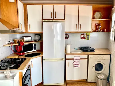 a kitchen with white cabinets and a refrigerator at Le Nouveau Port By SCLS Locations in Cannes