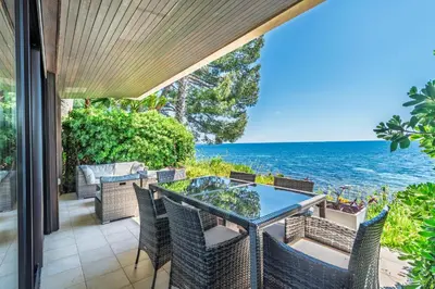 an outdoor patio with a table and chairs and the ocean at ADRIANA by Terry's Homes WATERFRONT SEAVIEW BEACH in Cannes