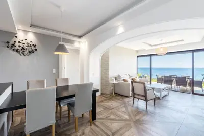 a dining room with a table and chairs and the ocean at ADRIANA by Terry's Homes WATERFRONT SEAVIEW BEACH in Cannes