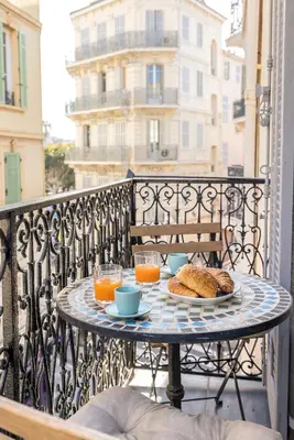 a table with a plate of food on a balcony at Appartement 2P centre de Cannes avec balcon in Cannes