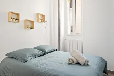a stuffed animal is sitting on a bed in a room at Appartement 2P centre de Cannes avec balcon in Cannes