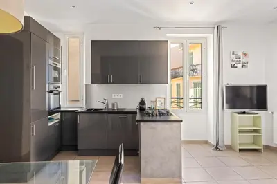 a kitchen with black cabinets and a counter top at Appartement 2P centre de Cannes avec balcon in Cannes