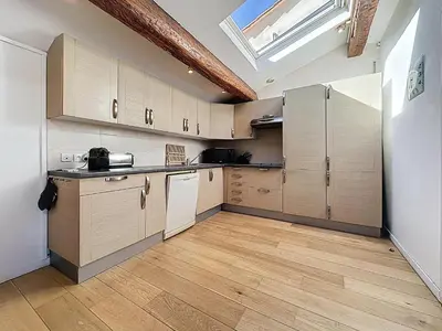 a kitchen with wooden cabinets and a skylight at Rooftop terrasse 1 bedroom in rue d'Antibes, 5 min from the Croisette 214 in Cannes