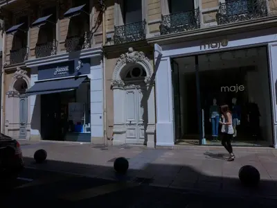a woman walks past a mike store on a city street at Rooftop terrasse 1 bedroom in rue d'Antibes, 5 min from the Croisette 214 in Cannes