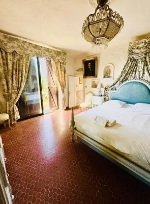 a bedroom with a blue bed and a chandelier at Somptuous exotic villa in Cannes in Cannes