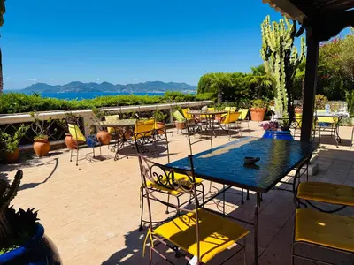 a table and chairs on a patio with a view at Somptuous exotic villa in Cannes in Cannes