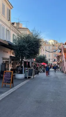 a street in a city with a tree and buildings at Beau meublé 3 pièces 60 m² Cannes Le Suquet in Cannes