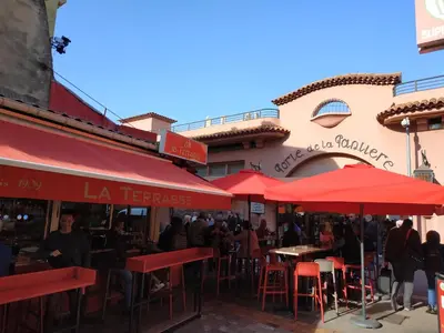 a restaurant with red umbrellas in front of a building at Beau meublé 3 pièces 60 m² Cannes Le Suquet in Cannes