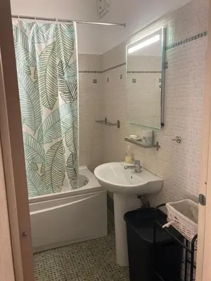 a bathroom with a sink and a shower curtain at Beau meublé 3 pièces 60 m² Cannes Le Suquet in Cannes
