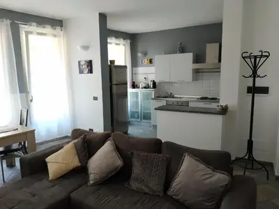 a living room with a brown couch and a kitchen at Beau meublé 3 pièces 60 m² Cannes Le Suquet in Cannes
