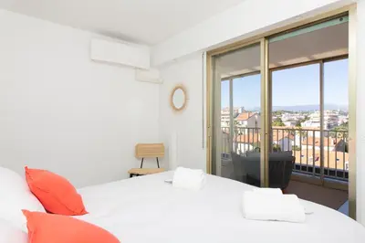 a bedroom with a white bed and a balcony at Rooftop View - 2 BdR 2 BthR 1 toil - Clim Terrace Elevator small Parking in Cannes