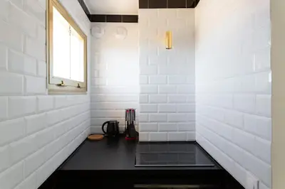 a bathroom with white tile walls and a black counter at Rooftop View - 2 BdR 2 BthR 1 toil - Clim Terrace Elevator small Parking in Cannes