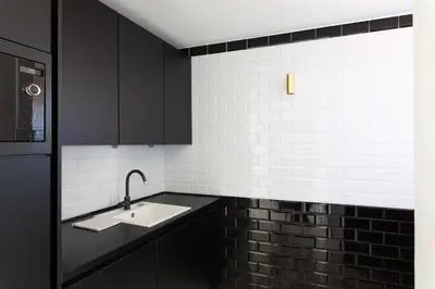 a kitchen with black cabinets and a sink at Rooftop View - 2 BdR 2 BthR 1 toil - Clim Terrace Elevator small Parking in Cannes