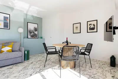 a living room with a table and chairs and a couch at Rooftop View - 2 BdR 2 BthR 1 toil - Clim Terrace Elevator small Parking in Cannes