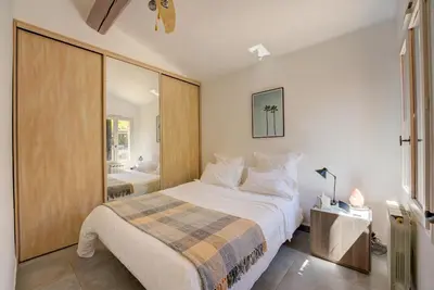 a bedroom with a large bed and a mirror at MAGNIFIQUE VILLA 8 PERSONNES in Vallauris