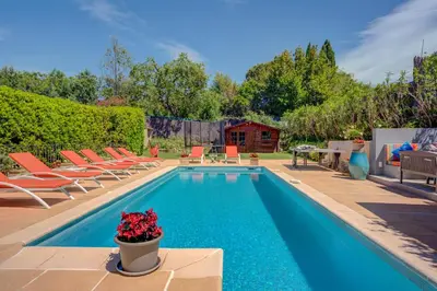 a swimming pool with chairs and aotted plant next to it at MAGNIFIQUE VILLA 8 PERSONNES in Vallauris